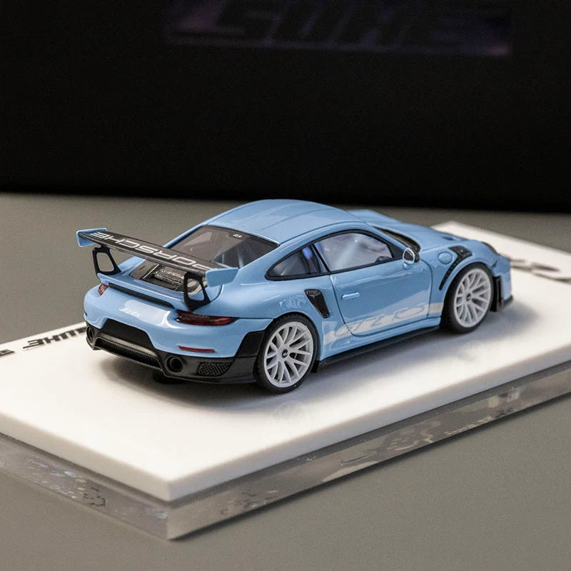 Blue model car on a white platform with a dark background