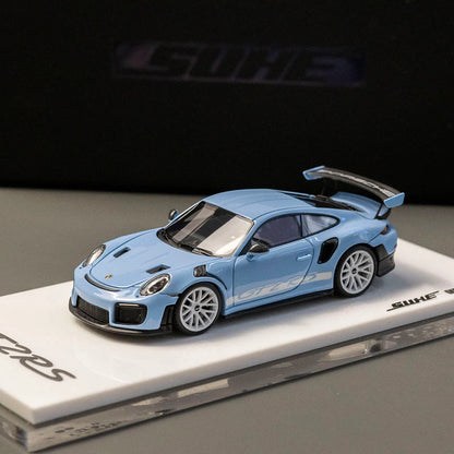 A light blue Porsche 911 GT2 diecast model car displayed on a white branded base against a dark background.