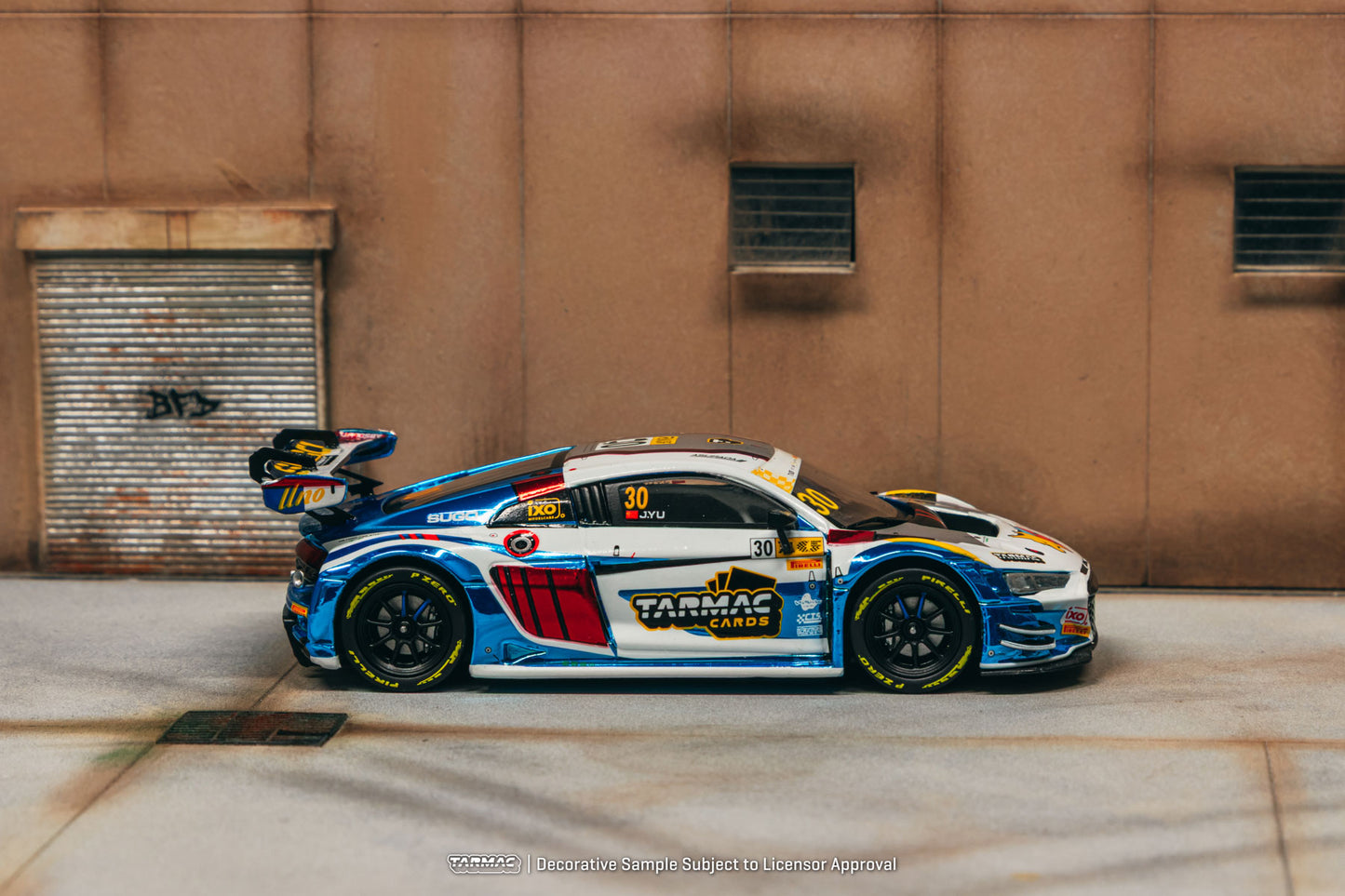 Race car with visible branding on a concrete surface against a brown wall.