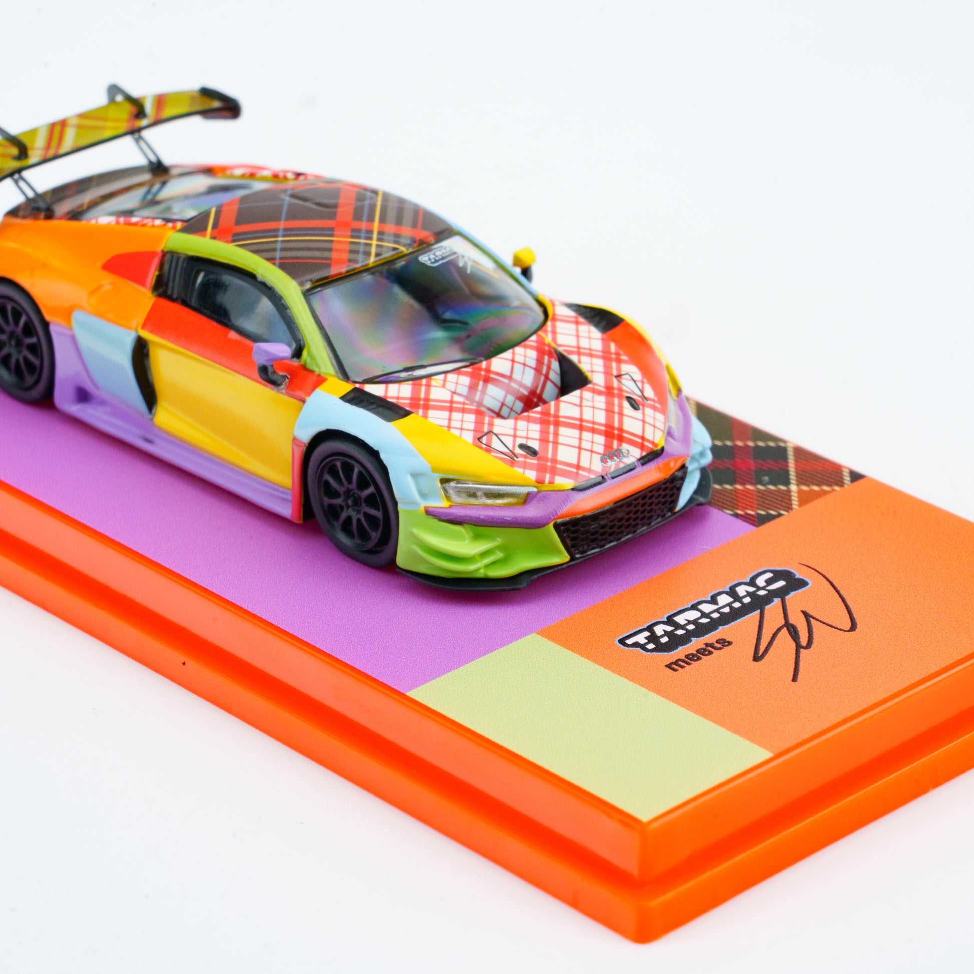 Colorful model car on a display stand with Tarmac Works branding