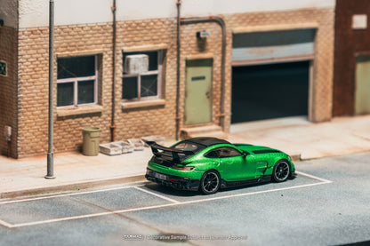 Green sports car on a model street with a brick building in the background