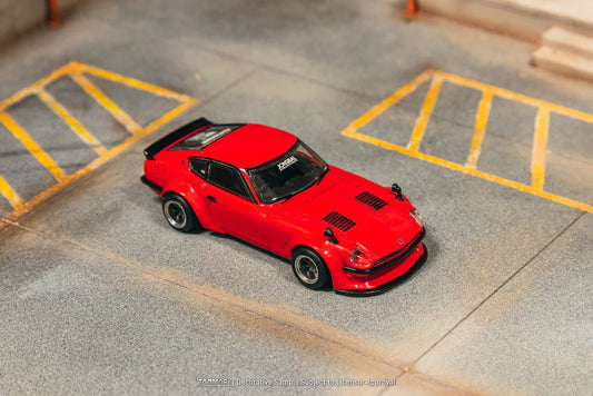 Red model car on a concrete surface with yellow lines