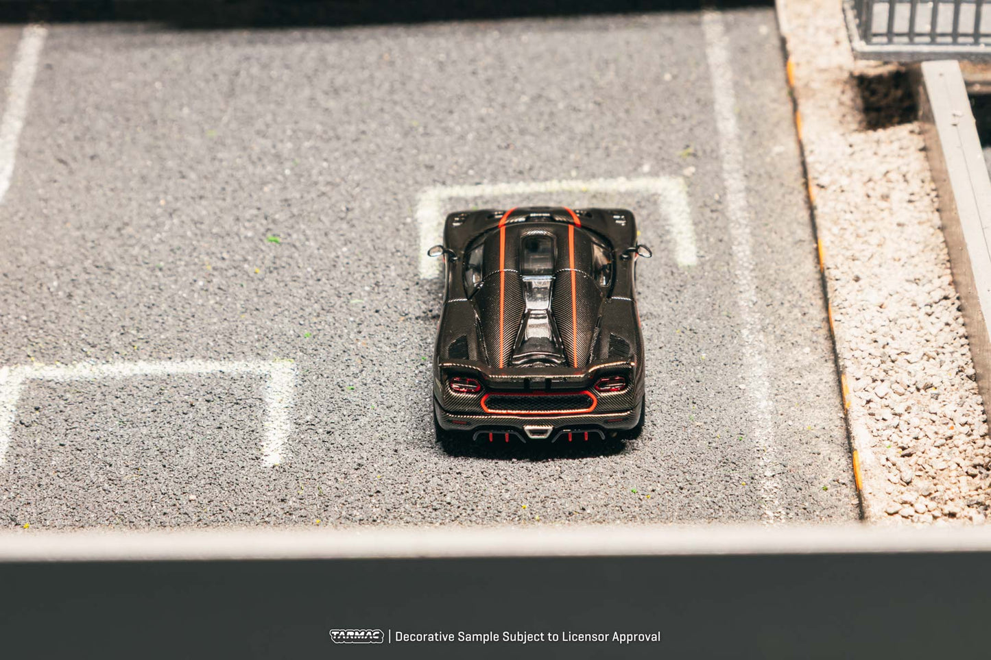 Model car on a miniature road with 'Hot Wheels' branding.