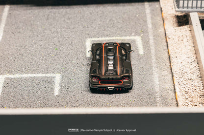 Model car on a miniature road with 'Hot Wheels' branding.