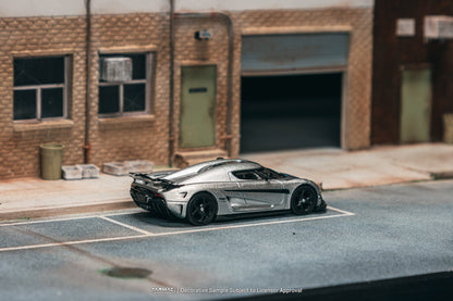 Model car on a scale model street with a building in the background