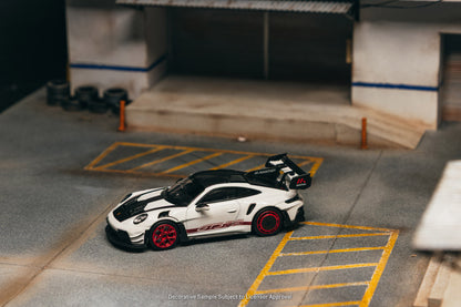 Model car on a miniature parking lot with buildings in the background