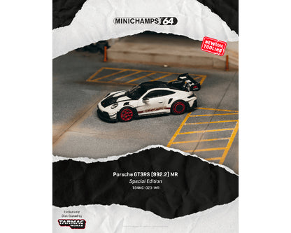 Model car of Porsche GT3 RS on a miniature racetrack with 'Minichamps 64' branding.