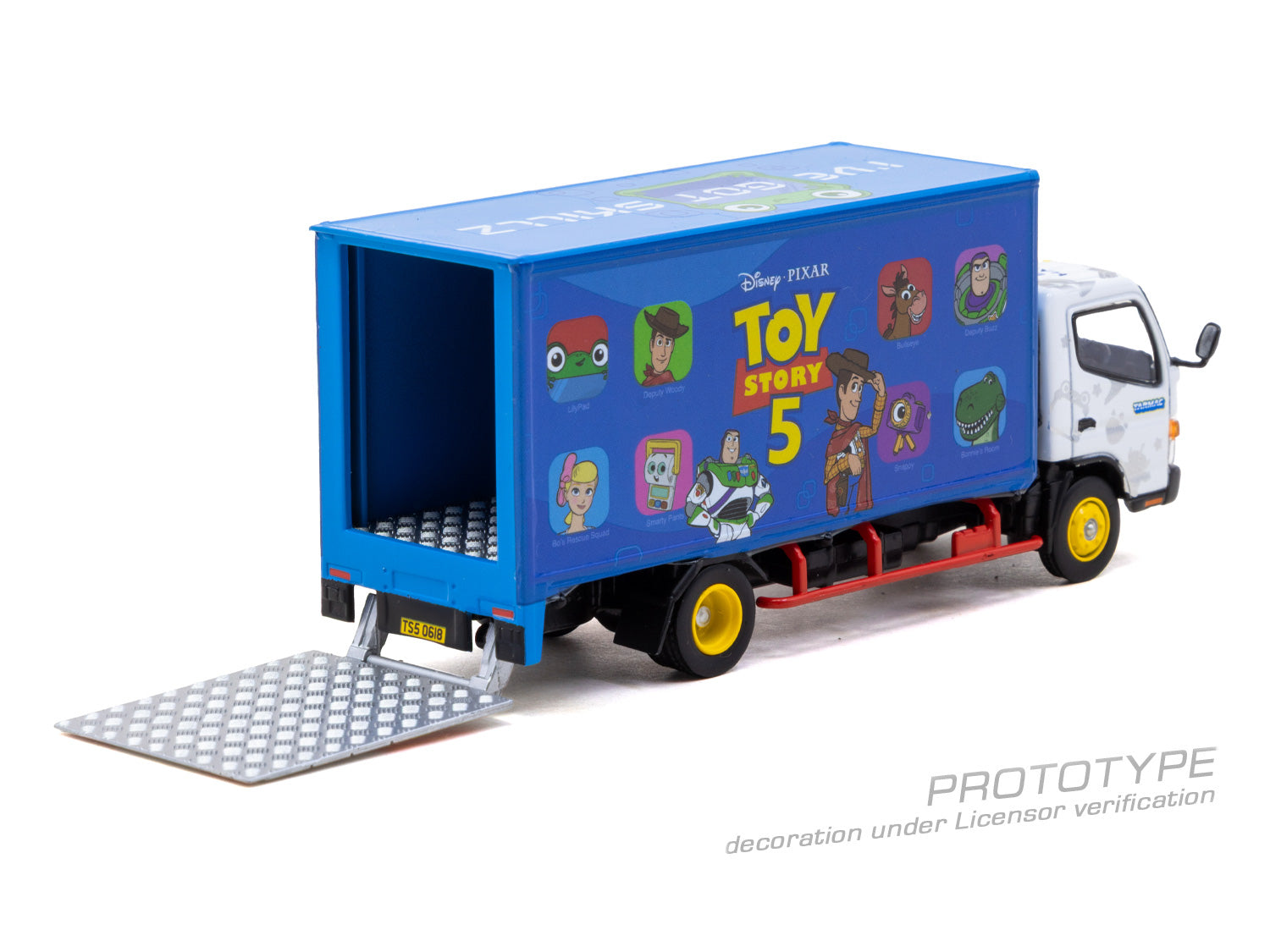 A diecast model of a Toy Story 5 box truck with a blue cargo container featuring character graphics, a white cab, and an open ramp with a diamond-plate pattern, shown on a white background.