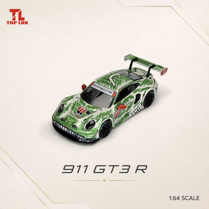 A 1:64 scale model of a Porsche 911 GT3 R race car with a green and white tropical leaf pattern, displayed on a light beige background with the 'TL TOP LUX' brand logo in the top-left corner.