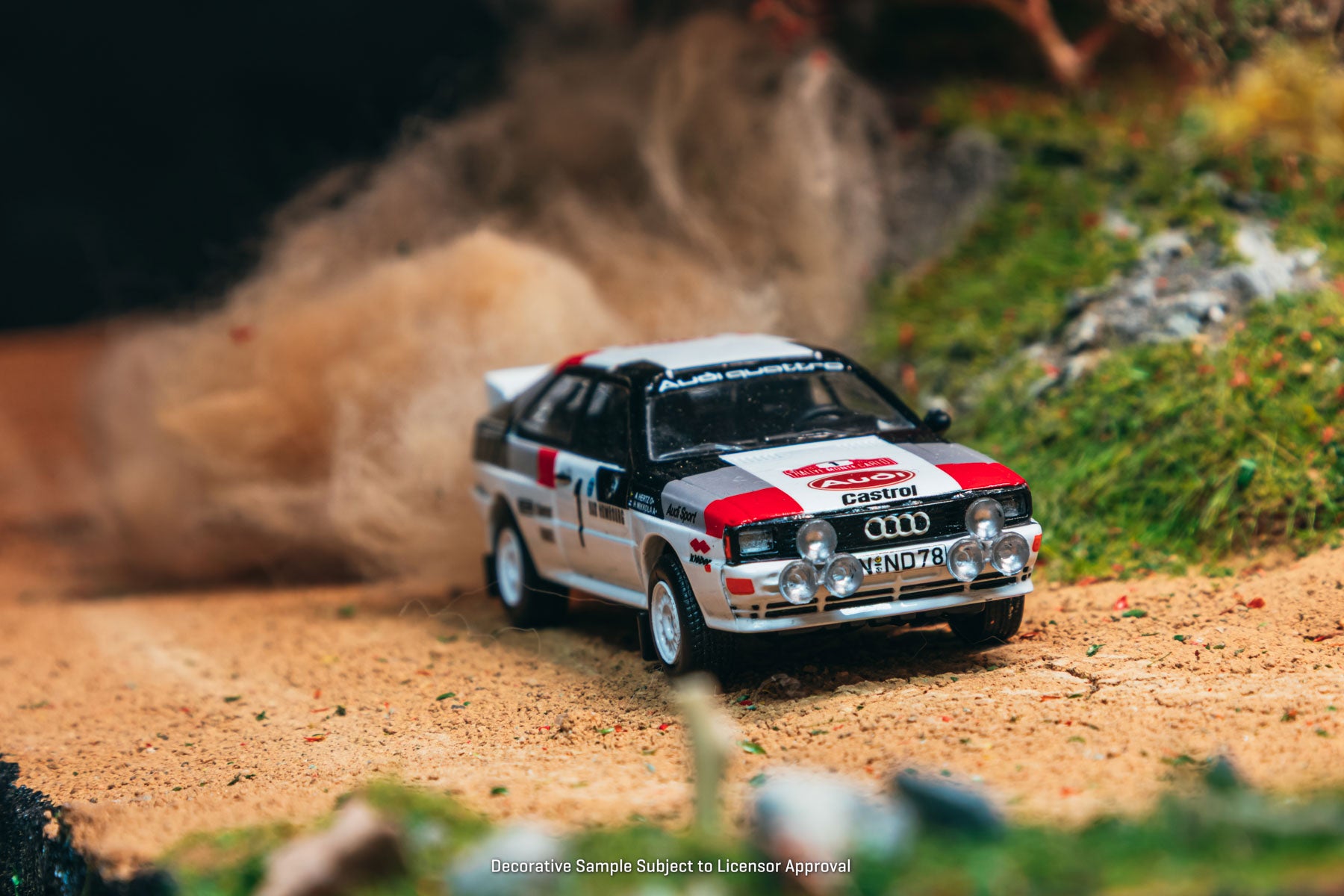 Model Audi race car on a dirt track with a blurred background