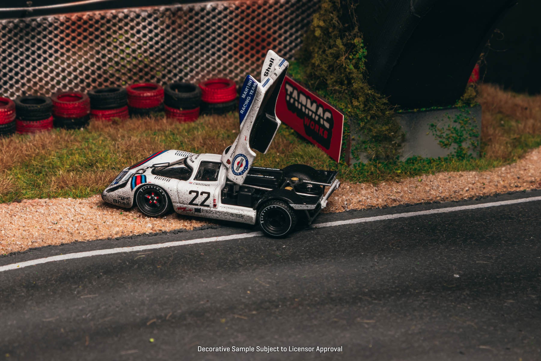 Model race car with open door on a track, featuring a visible brand logo.