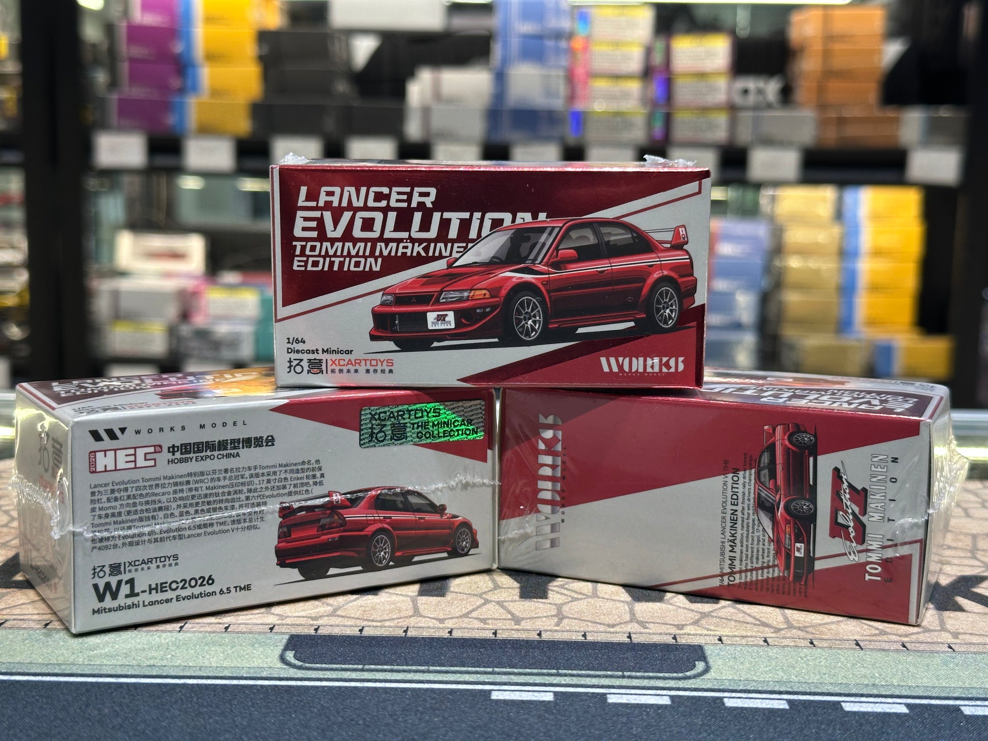 Model car boxes with 'Lancer Evolution' and 'Tommi Makinen Edition' on a blurred background