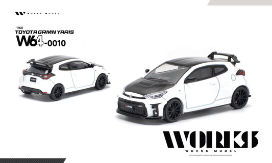 A 1/64 scale diecast model car of a white and black Toyota Gamin Yaris W640010, shown from both front-three-quarter and rear-three-quarter angles on a clean white background with WORKS MODEL branding.