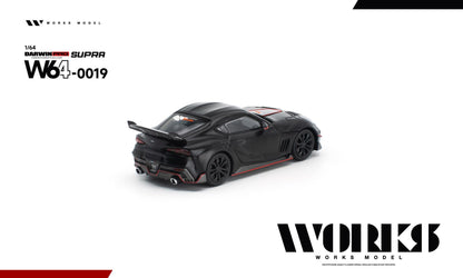 Rear three-quarter view of the Works Model 1:64 Toyota GR Supra DarwinPRO Aerodynamics Evolution in matte black with red accents, carbon-style diffuser, dual exhaust, black wheels, and rear spoiler. Product code W64-0019. Prototype diecast model displayed on a white background.