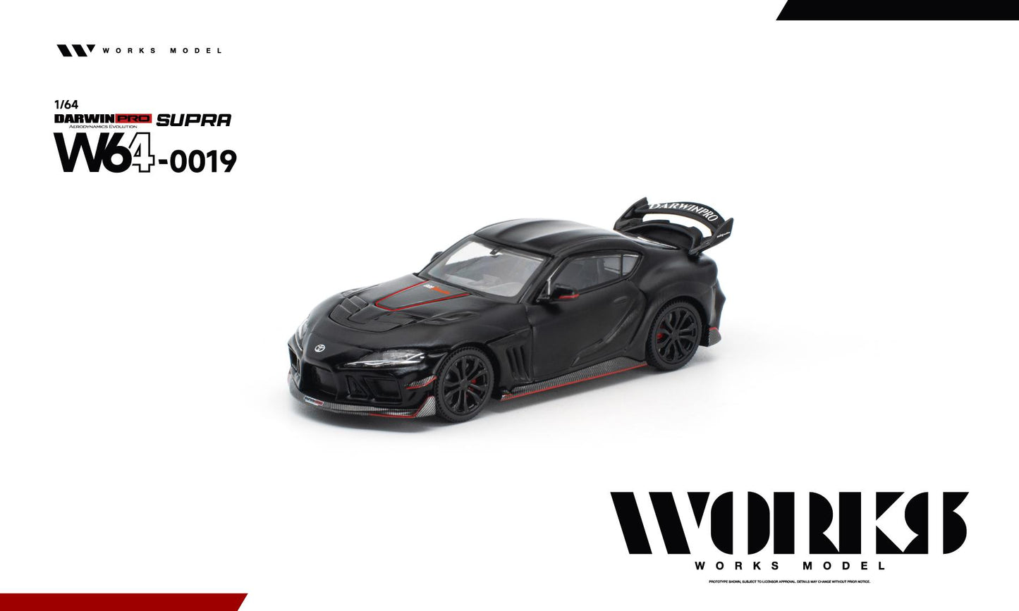 Front three-quarter view of the Works Model 1:64 Toyota GR Supra DarwinPRO Aerodynamics Evolution in matte black with red accents, carbon-style front splitter, vented hood, black wheels, and oversized rear wing. Product code W64-0019. Prototype diecast model on a white background.