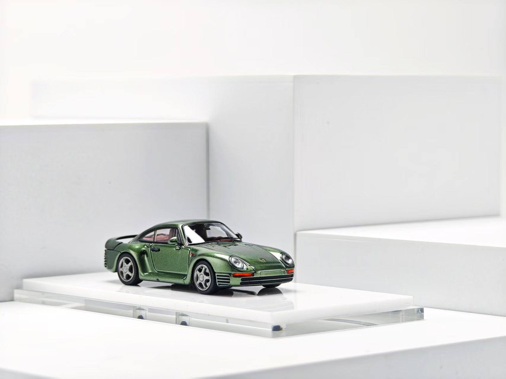 Model of a green sports car on a white platform with a white background