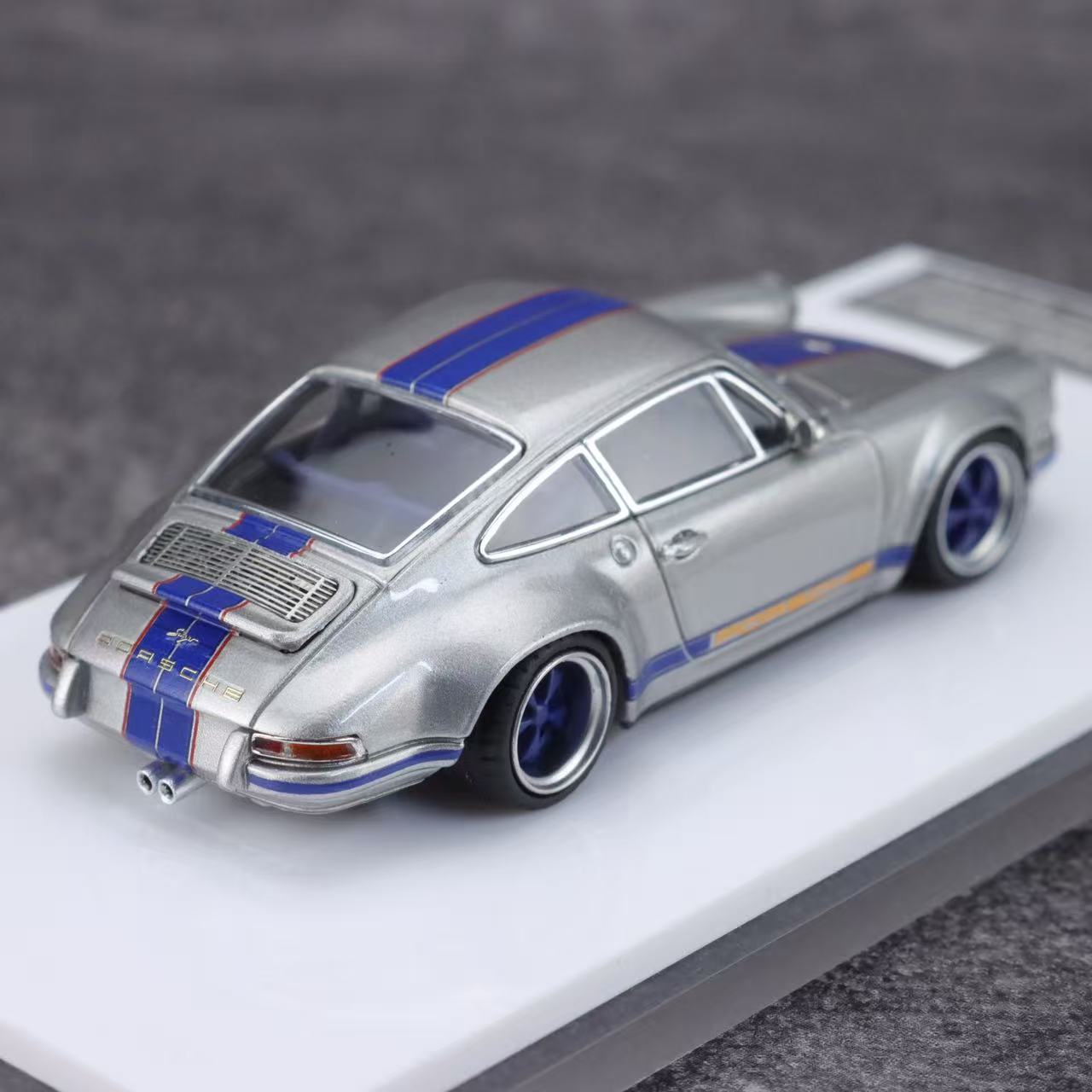 Model car with blue stripes on a gray background