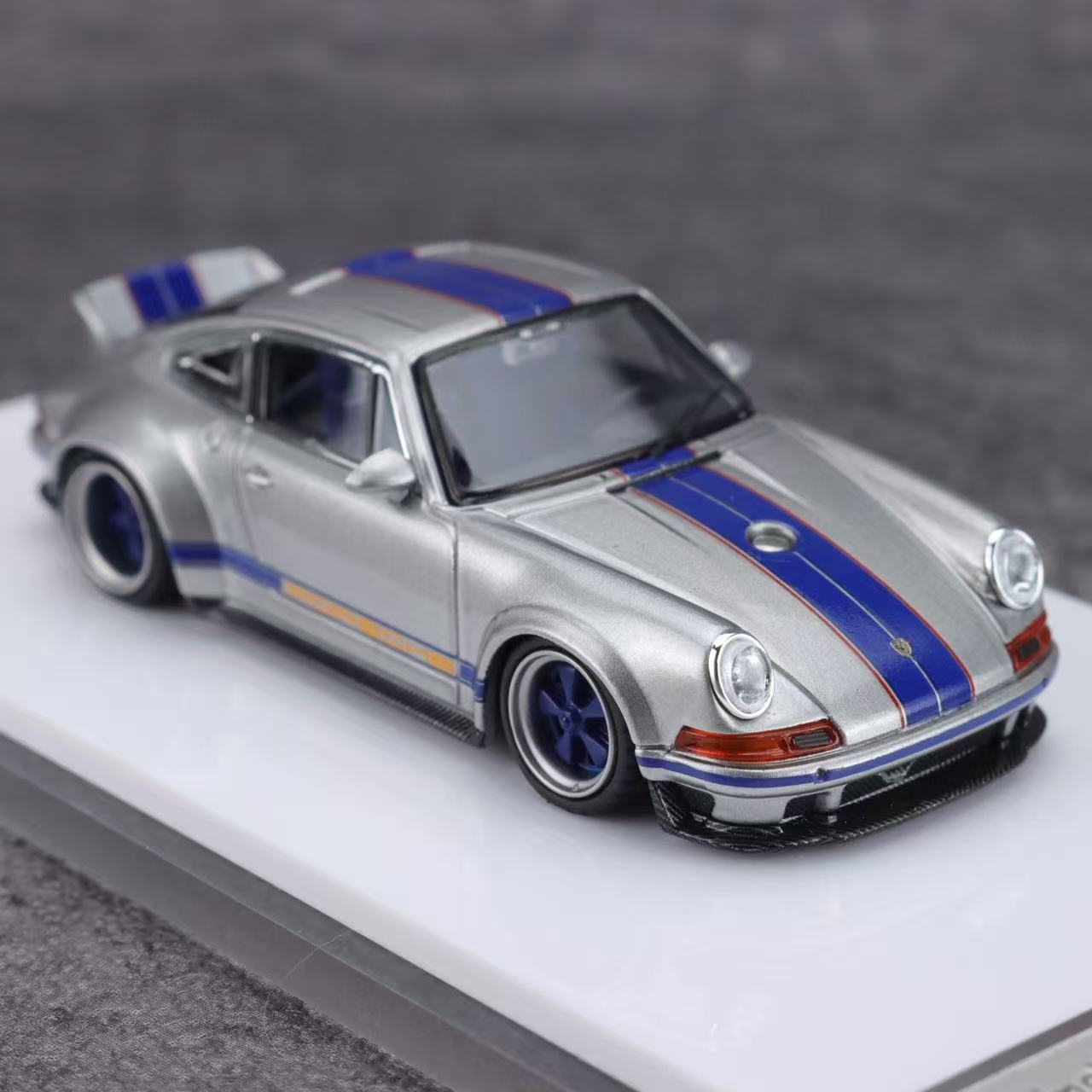 Model car with blue stripes on a gray background