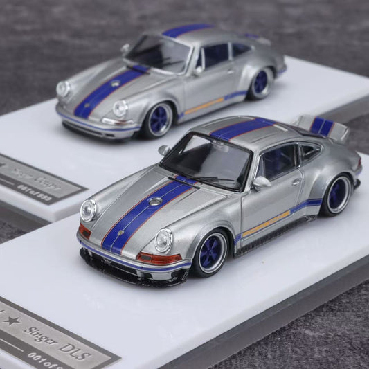 Two model cars, a silver and blue Porsche with stripes, on display stands.