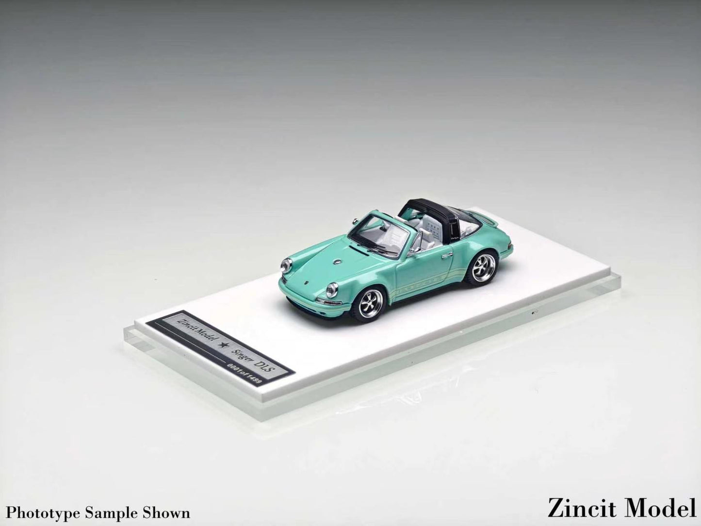 A mint green die-cast model car displayed on a clear acrylic base with a label, photographed on a neutral gray studio background. The model appears to be a Porsche 356 convertible, and the image includes the text 'Zincit Model' and 'Prototype Sample Shown'.