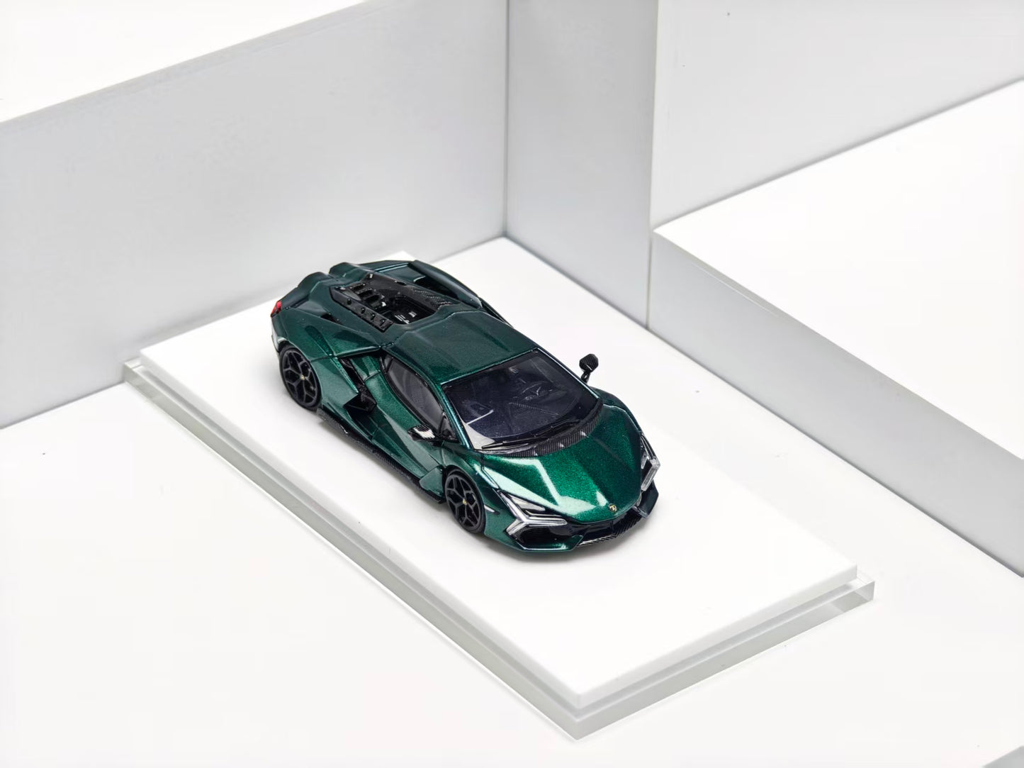 Green sports car model on a white platform