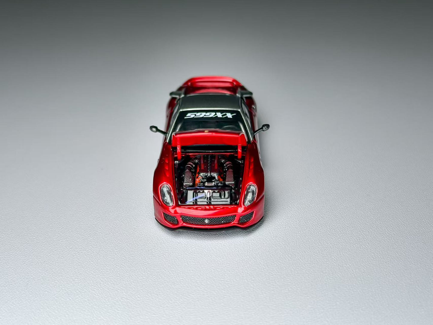 Red toy car with open hood on a gray background