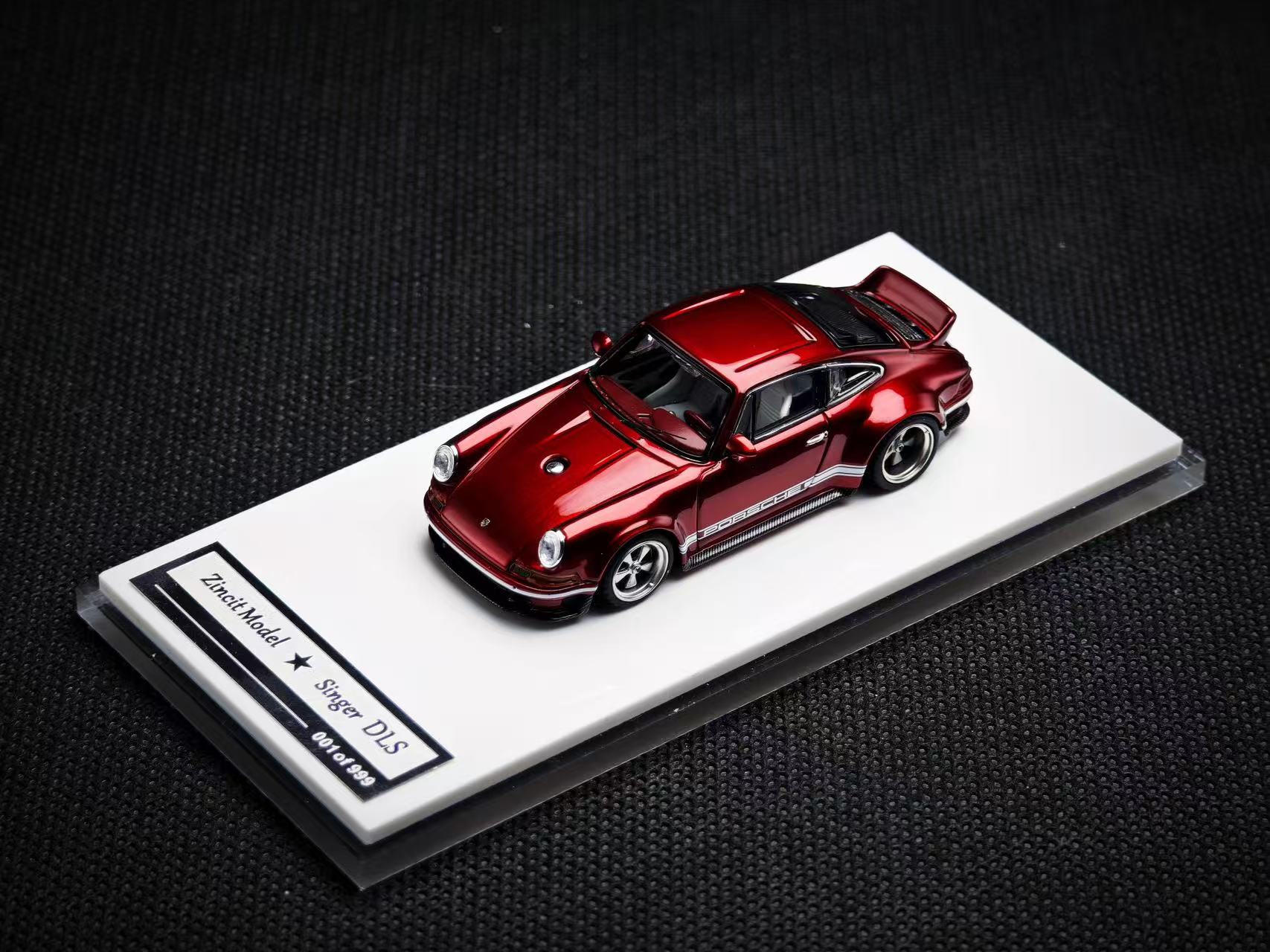 Red model car on a display stand with a dark background