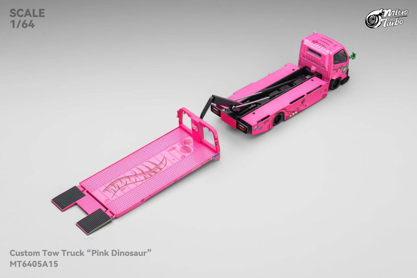 Model pink tow truck with open flatbed on a gray background