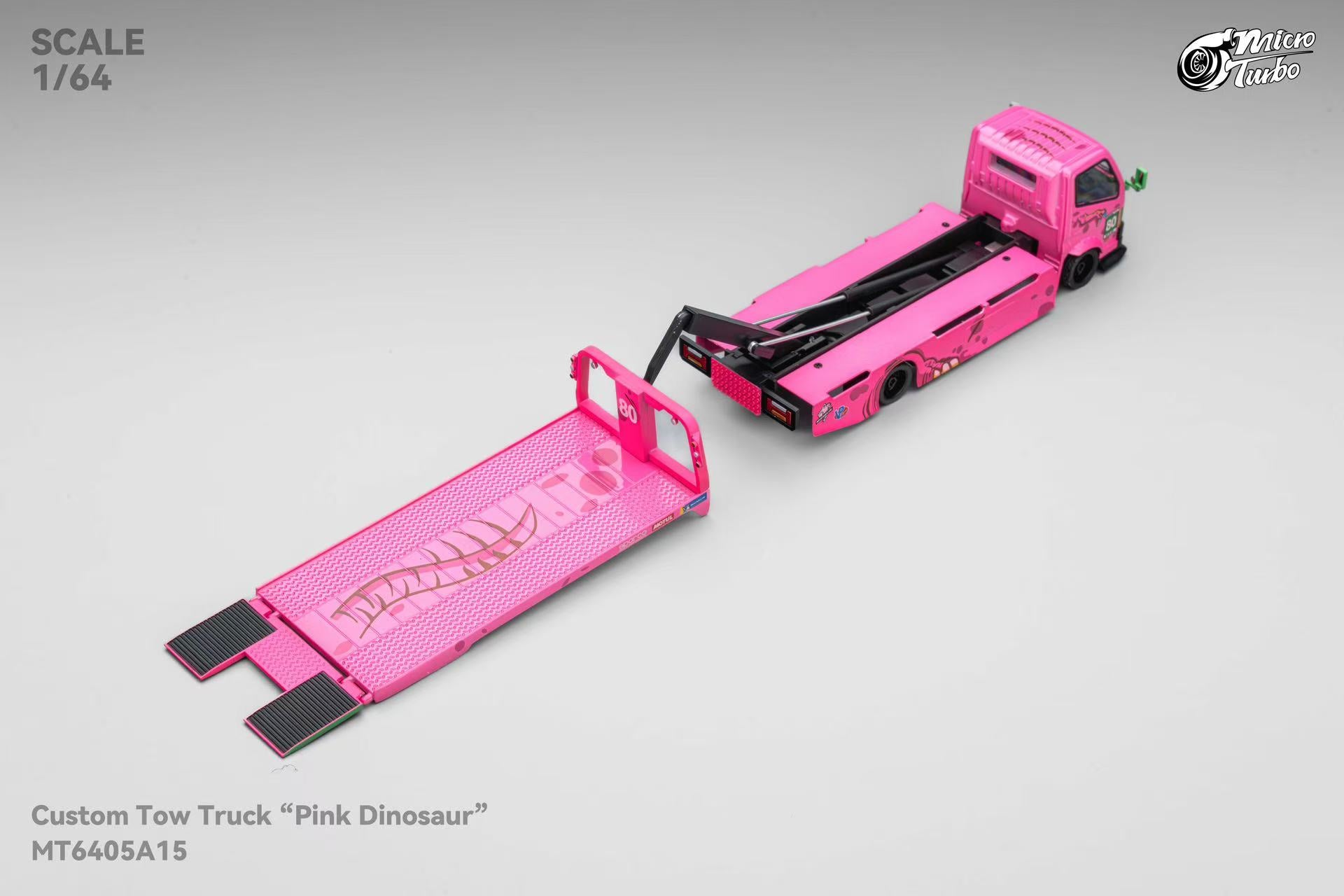 Model pink tow truck with open flatbed on a gray background