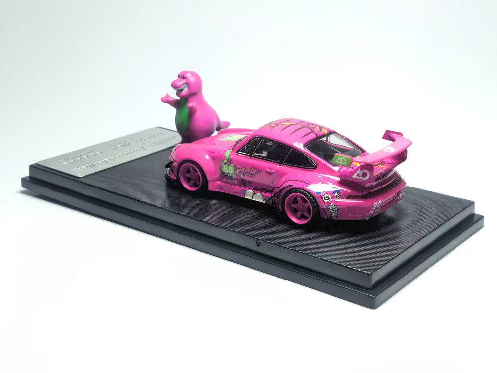 Pink toy car with a dinosaur figure on a black platform