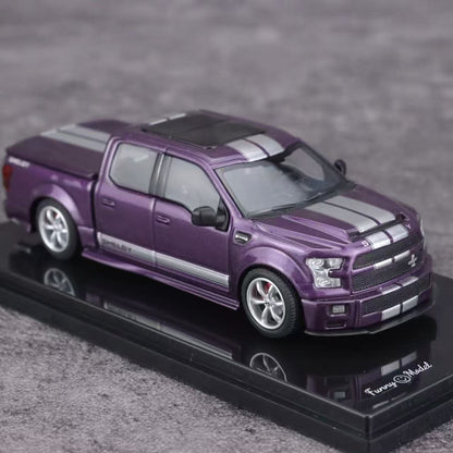 Purple model truck on a reflective surface with a blurred background