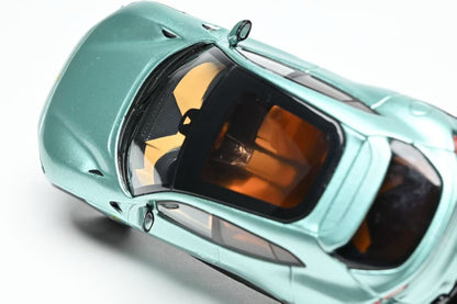 Close-up of a teal toy car with open door on a white background