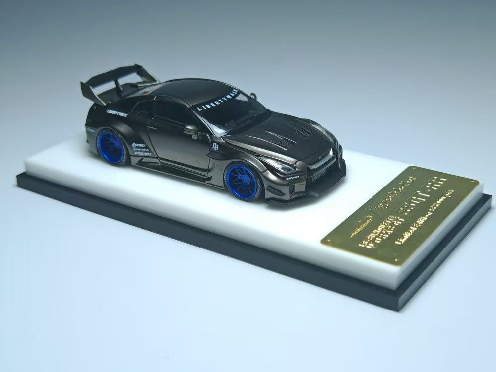 Black sports car model on a white platform with a gold plaque