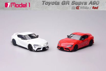 Two toy model cars, one white and one red, on a gray background with 'Toyota GR Supra A90' text.