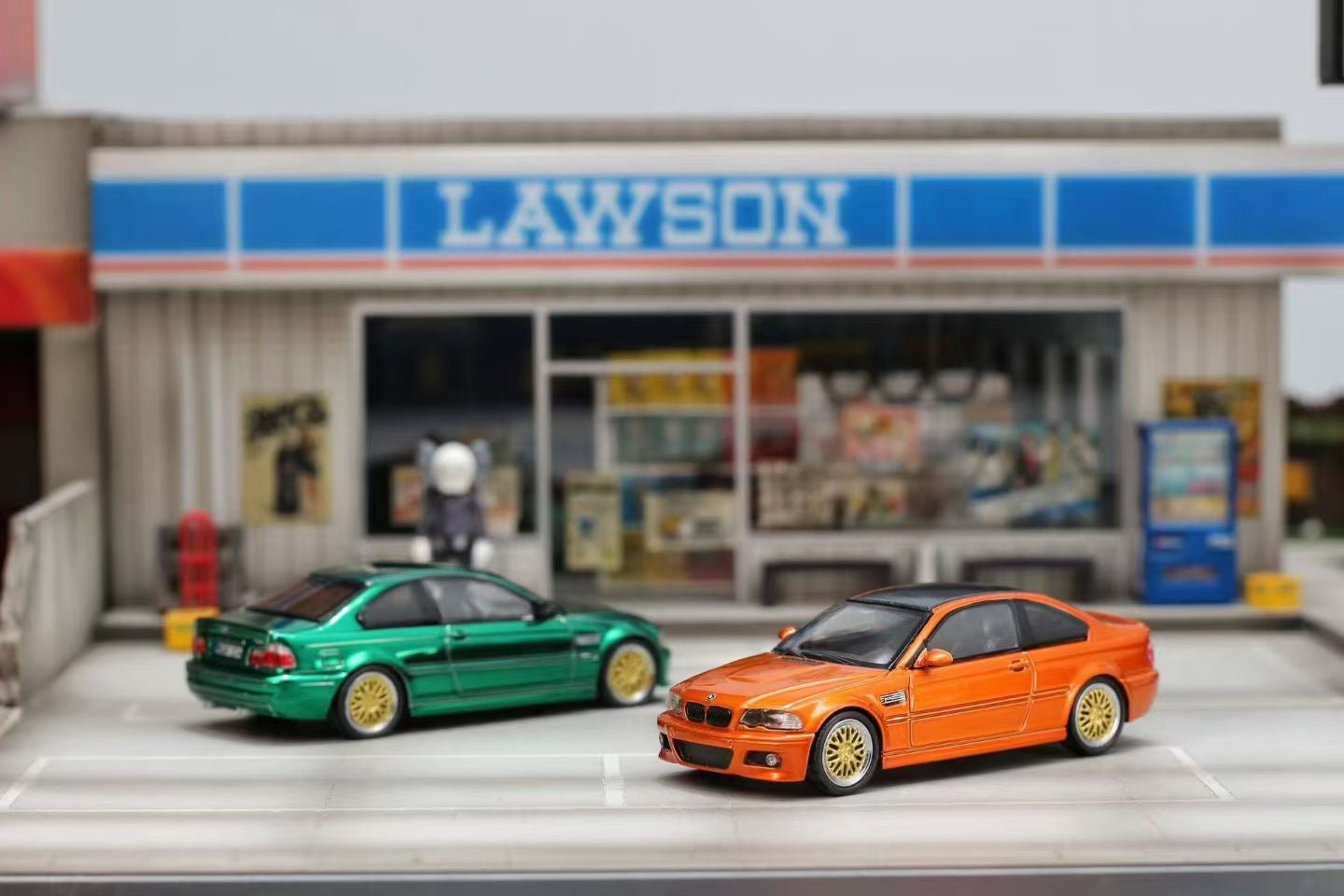 Two toy cars in front of a Lawson store.