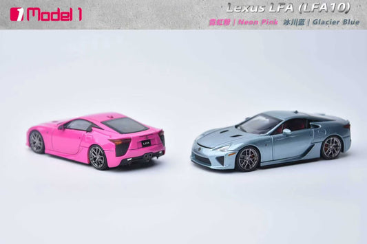 Two toy model cars, one pink and one gray, on a light gray background.