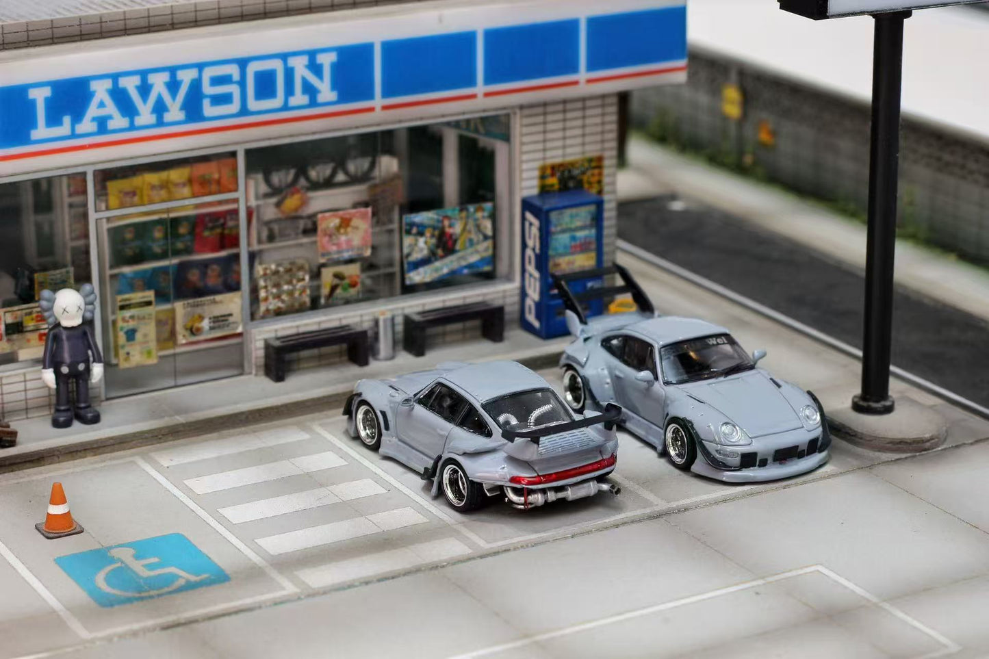 Model cars parked in front of a Lawson convenience store.