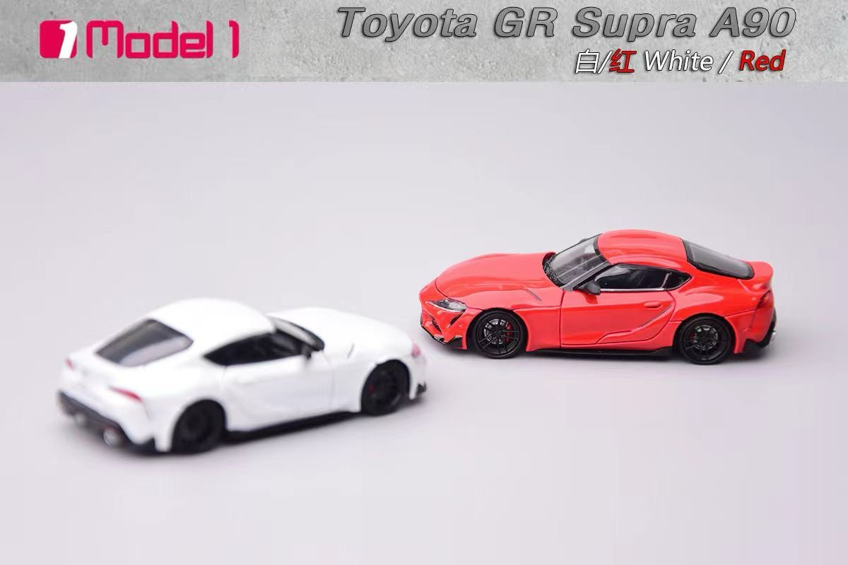 Two toy cars, one white and one red, with 'Toyota GR Supra A90' branding on a gray background.
