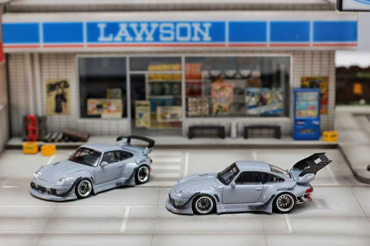 Two model cars in front of a Lawson convenience store.