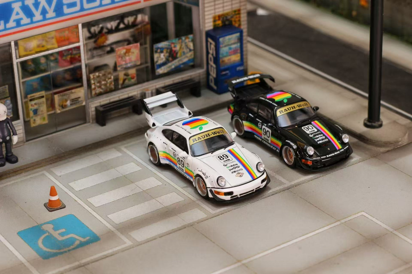 Model cars on a miniature street with a store and traffic cone in the background