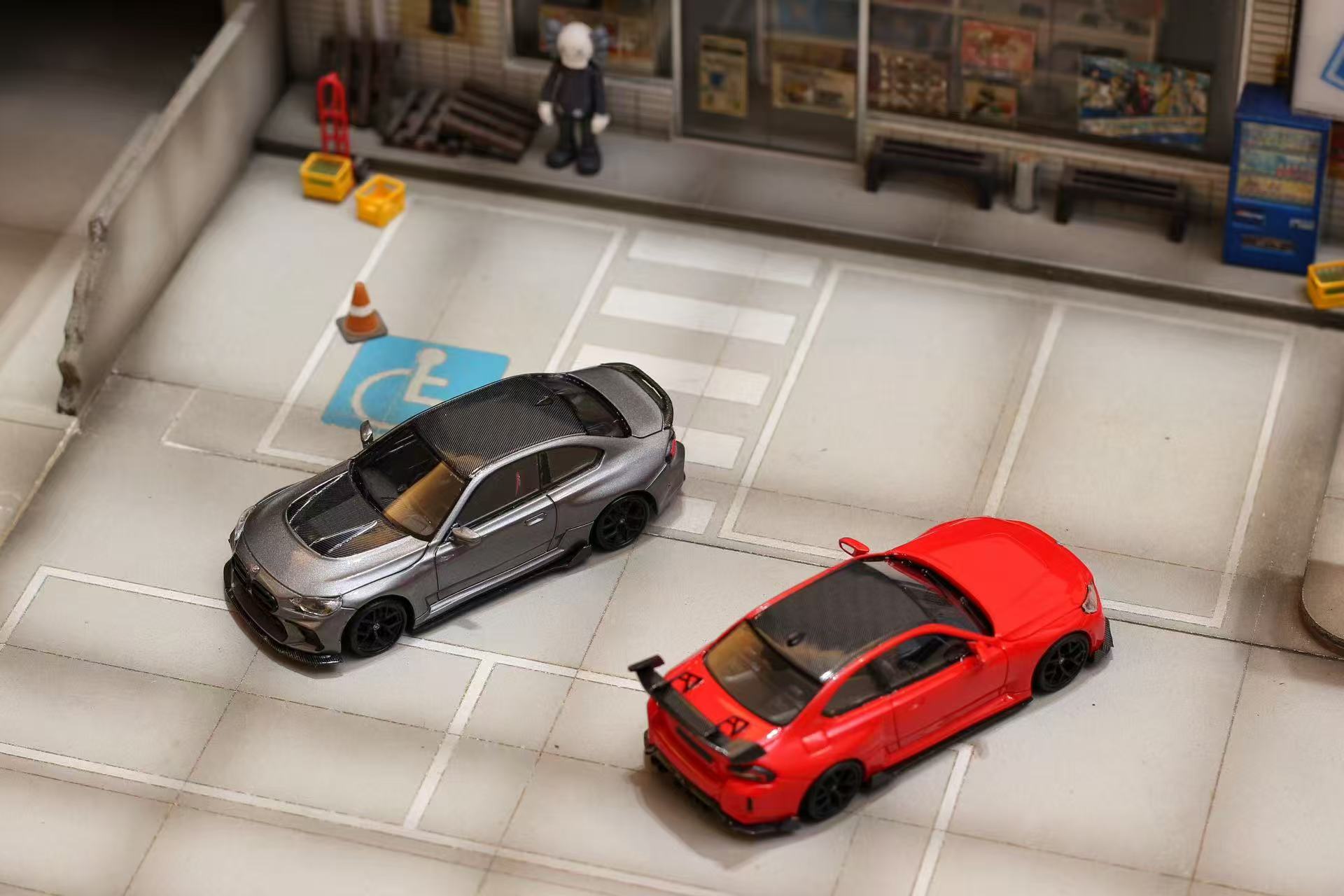 Two toy cars, one red and one black, on a tiled floor with a miniature store in the background.